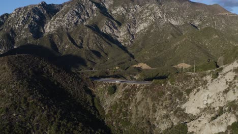 hermoso vuelo aéreo sobre la carretera en las montañas verdes durante la hora dorada