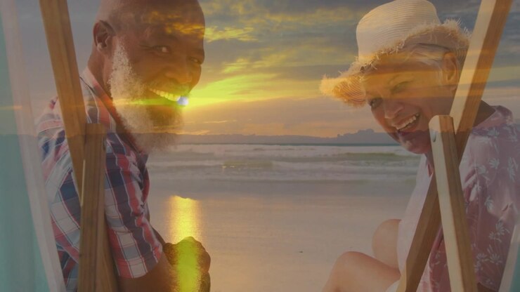 Man and woman sitting in beach chairs, sun dissolving into overlay, turning smiling for marketing