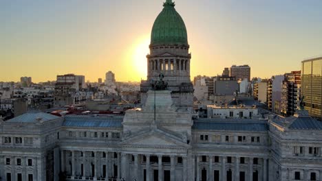 aerial dolly out of argentine congress palace with green bronze dome at golden hour with buenos aires buildings in background