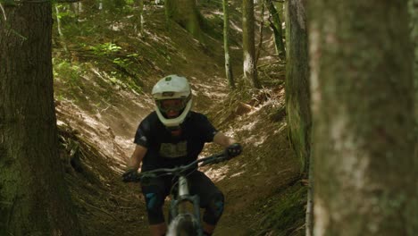 mountainbiker kerft een geul uit en stoot stof op onder een lichtstraal