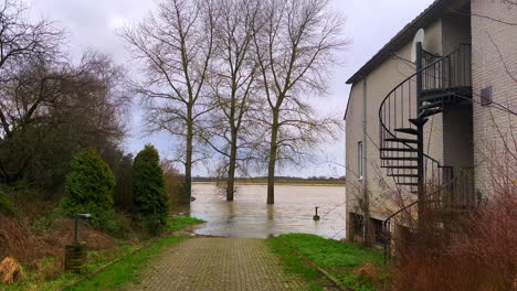 river water flooding to house on shore threating to drown building