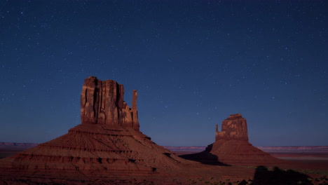 monument valley buttes under a starry night sky