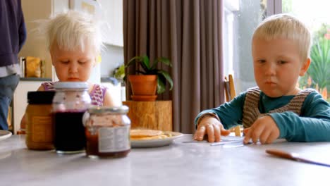 hermanos comiendo panqueques en la mesa de comedor 4k
