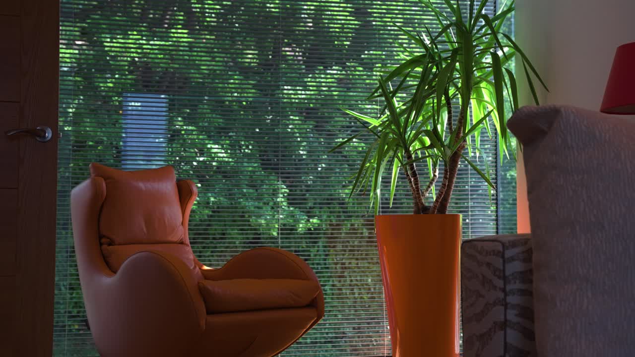 Cozy reading room with orange chair, plant, and passing light