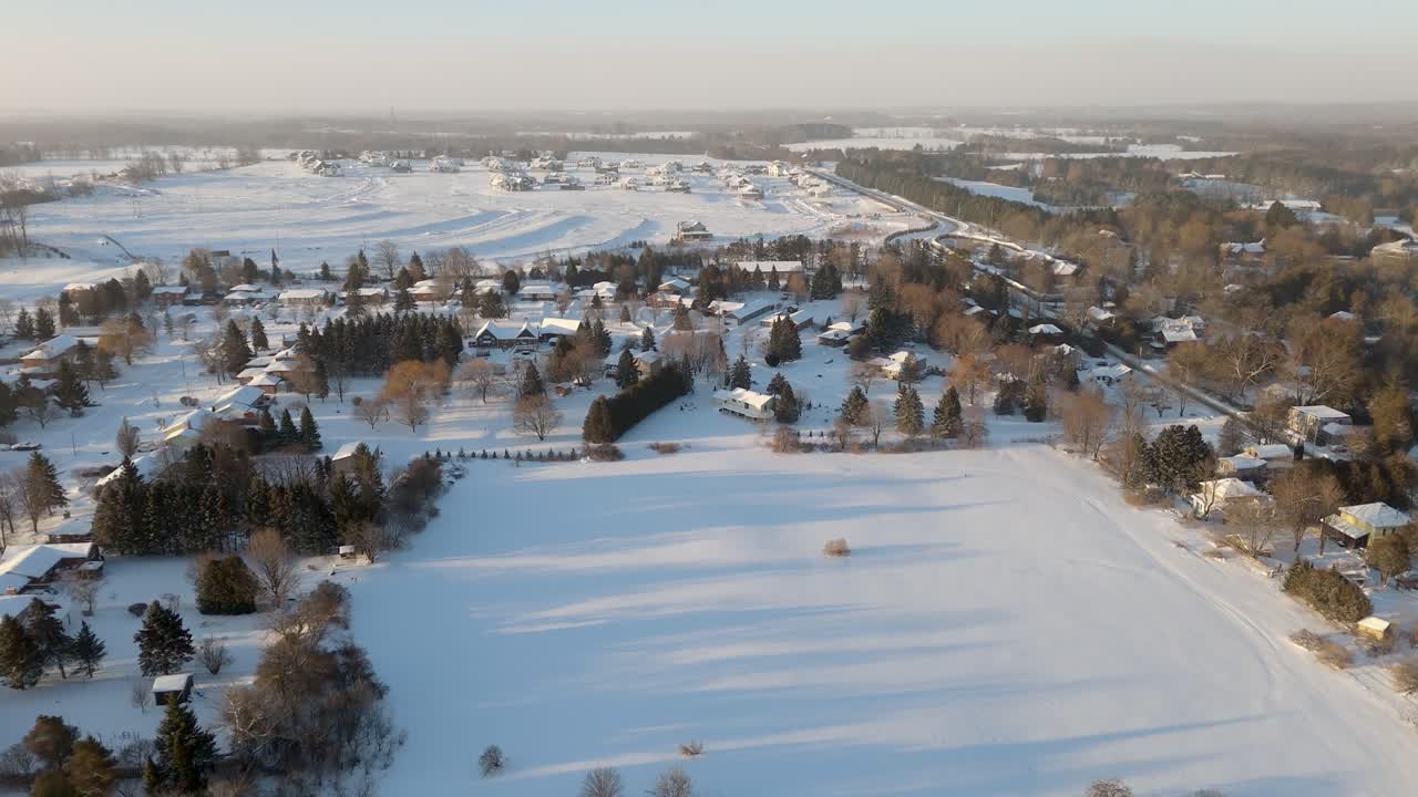 Aerial Flyover Of A Snow Covered Field Surrounded By Homes In A Neighbourhood Of Alton, Caledon.