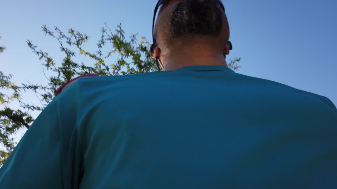 A close up shot of the head and chest of a running man from below