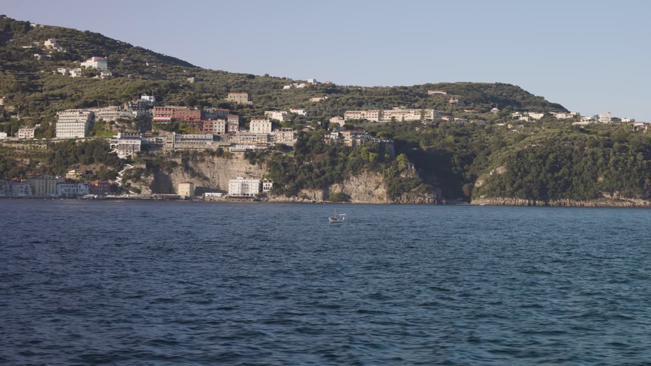 Small Boat Speeding Along the Coast of Capri, Italy with Rocky Mountains and Blue Mediterranean Sea in the Background