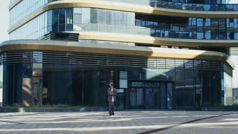 un hombre de negocios caminando frente a un edificio de oficinas moderno