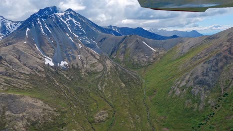 volando a lo largo de picos montañosos remotos en el valle de matanuska, cordillera de talkeetna, alaska
