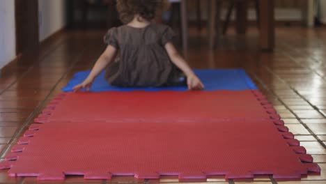linda niña de 4 años haciendo volteretas en el suelo