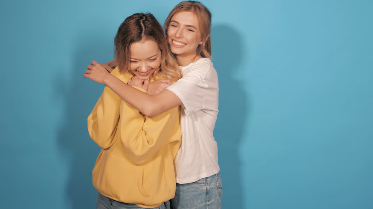 두 명의 행복한 친구들이 포옹하고 있습니다.