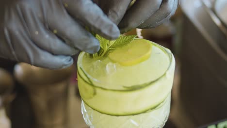 bartender prepares cocktail with black gloves. slow-motion and close up