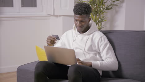 portrait of smiling man paying with credit card in online shop