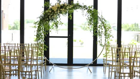 circular floral wedding altar and glass wall behind, dolly shot