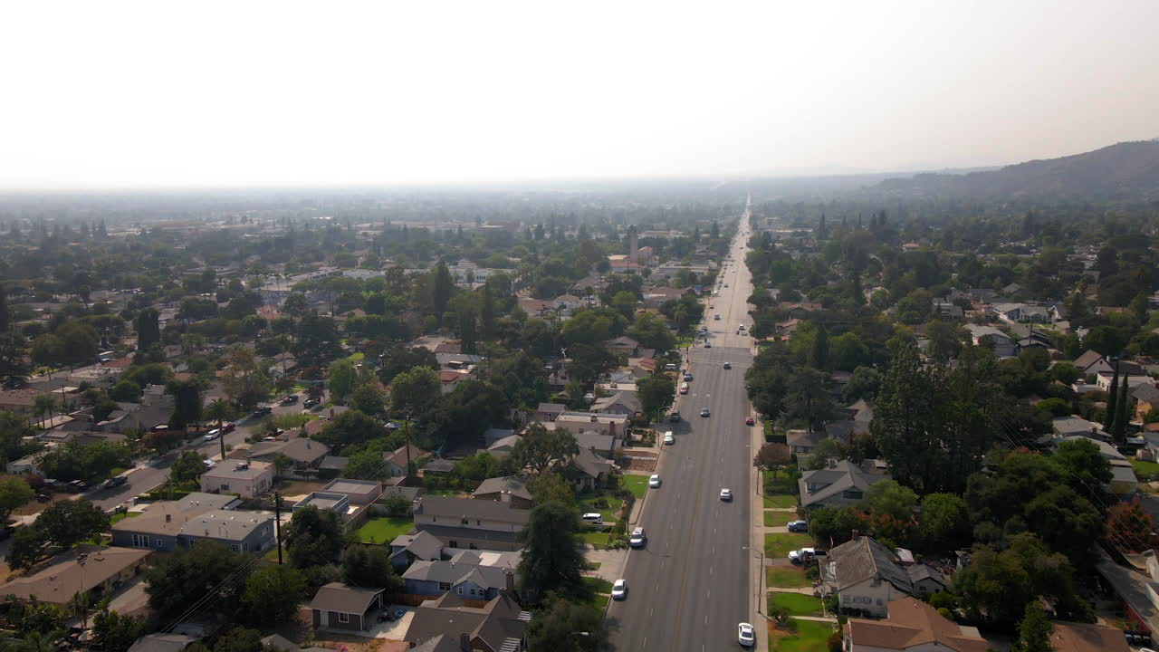Vista aerea di un quartiere suburbano nebbioso con una lunga strada dritta