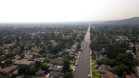 aerial view of a hazy suburban neighborhood with a long straight road