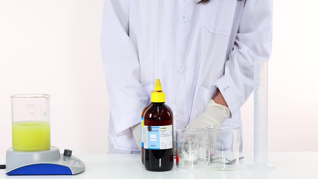 과학자는 요오드 시계 반응으로 색이 은 색에서 어두운 색으로 변하는 것을 보여줍니다.