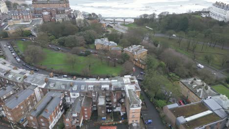 Toma-Aérea-De-La-Arquitectura-Antigua-De-Los-Edificios-De-La-Bahía-De-Scarborough-Durante-El-Día-Junto-Al-Mar-En-Scarborough,-Inglaterra