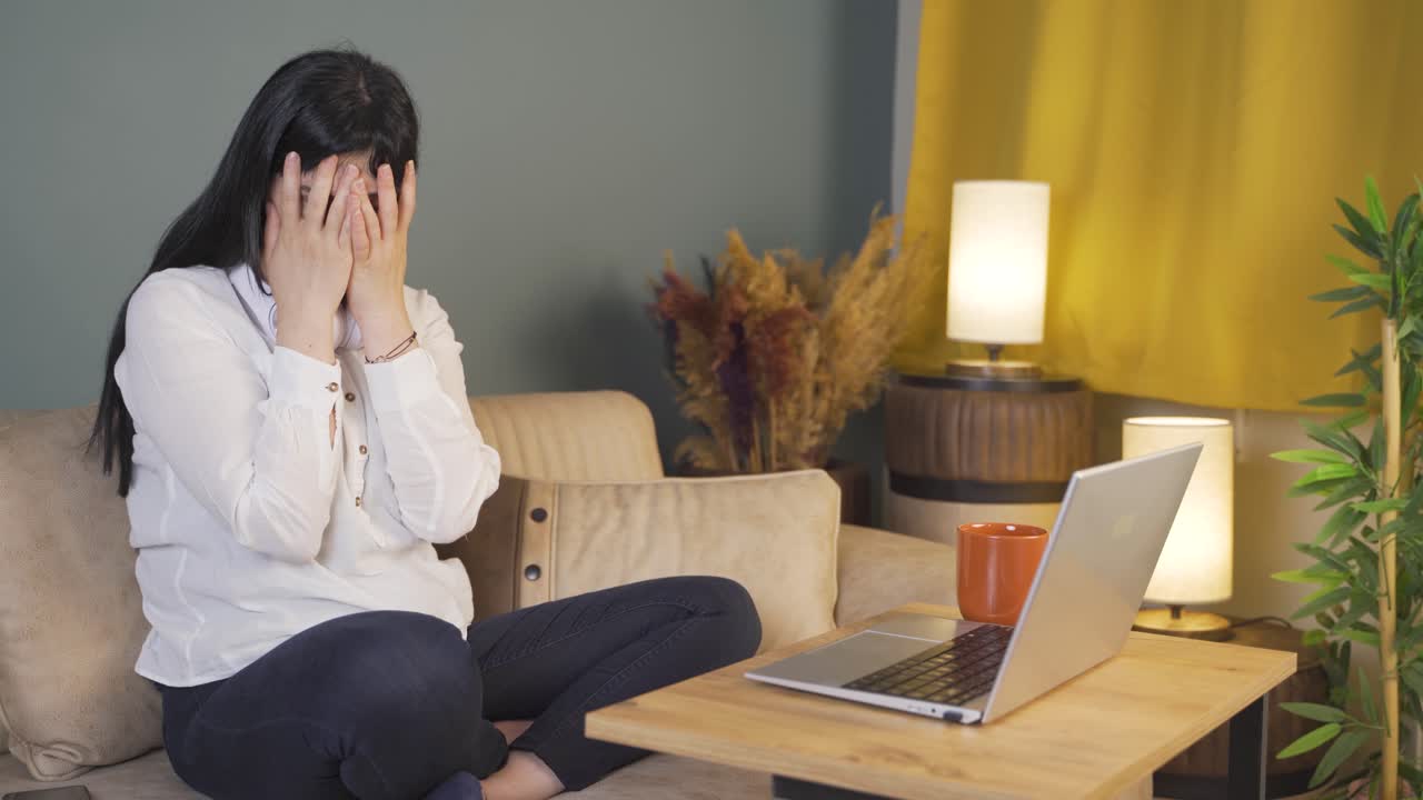 밤에 노트북에서 공포 영화를 보는 여성. 여성은 겁에 질려 있고 긴장합니다.