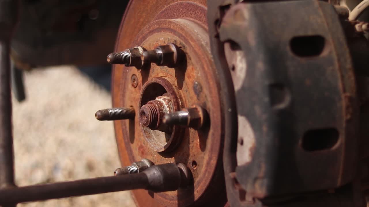 Close up of a car wheel hub with a cross wrench being used to tighten a lug nut
