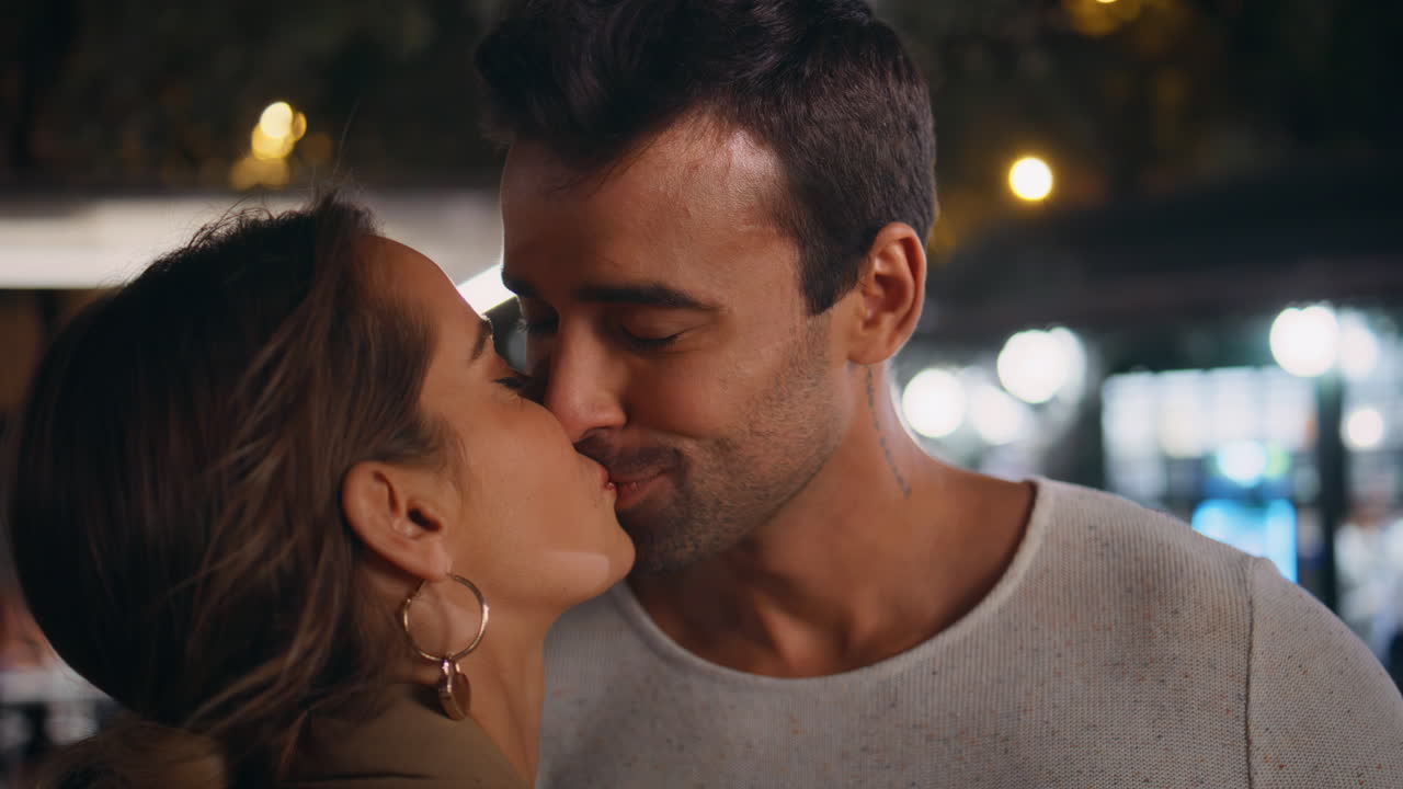 Happy couple kissing street in night closeup. Smiling lovers enjoying dating