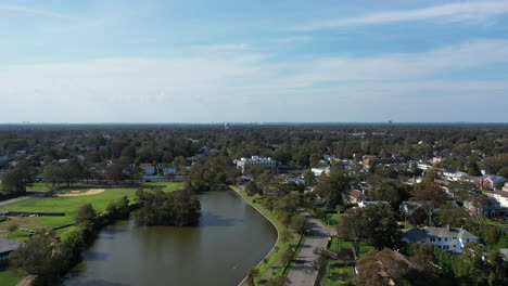 An-aerial-drone-shot-over-a-green-pond-in-a-suburban-neighborhood-on-Long-Island,-NY