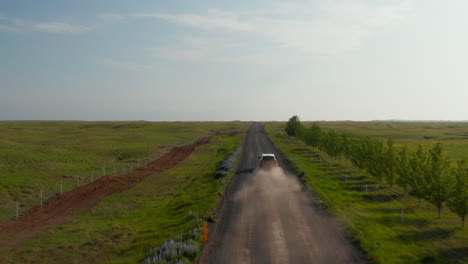 Aerial-view-flying-towards-adventurous-car-driving-on-Ring-Road,-a-national-road-that-runs-around-Iceland-and-connects-most-of-the-inhabited-parts-of-the-country.-Commercial-drone-view