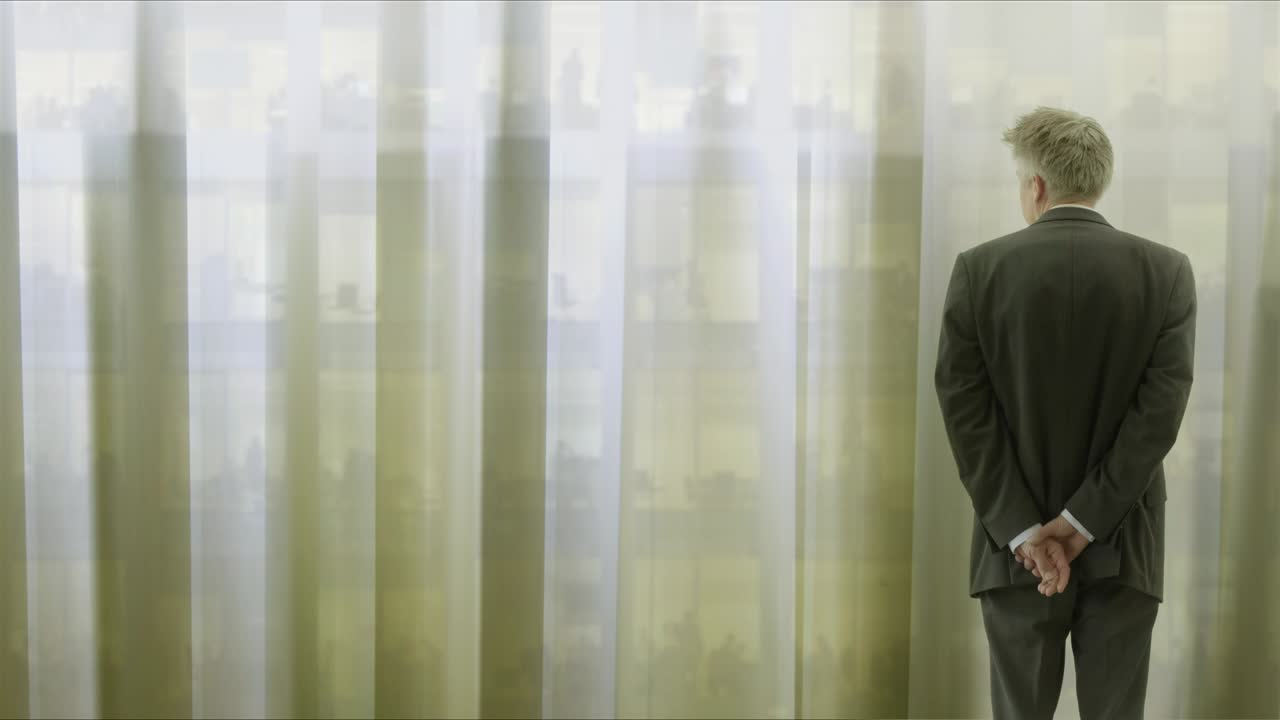 커튼을 통해 보는 외로운 사업가