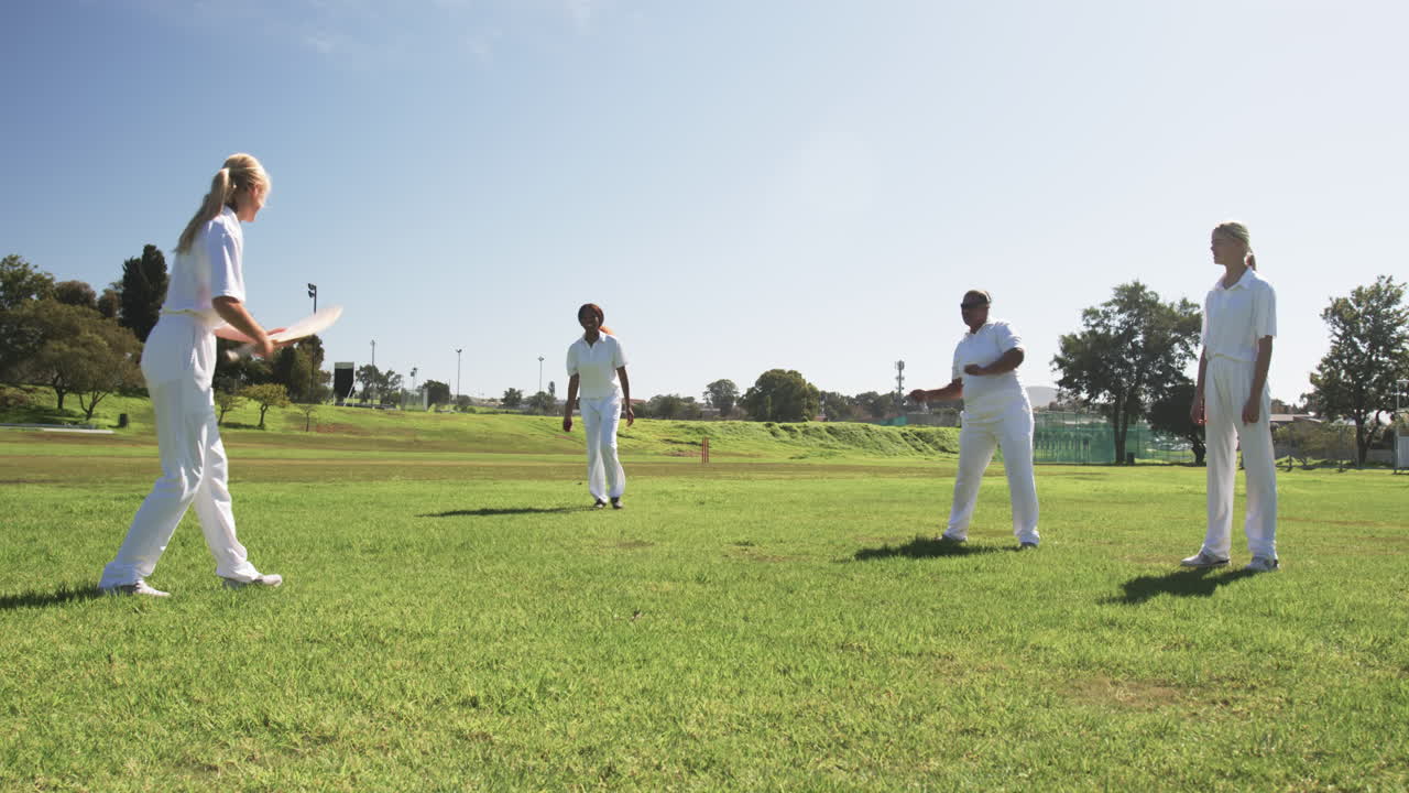 Playing cricket, women in white uniforms enjoying outdoor sports activity