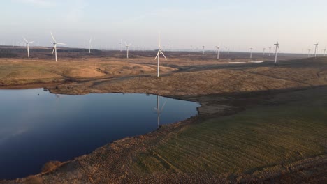 Wind-turbine-reflecting-over-lake-waters,-Scotland