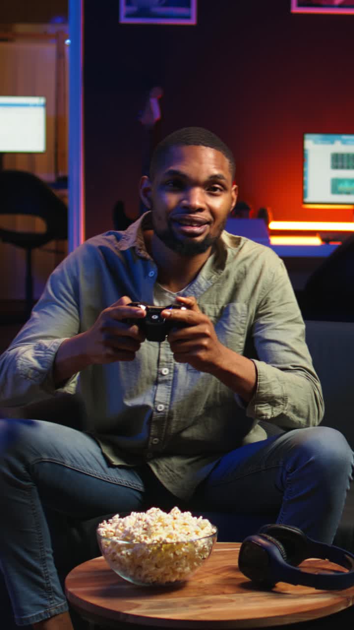 Vertical Video POV young black adult enjoying free time playing shooter games on smart tv