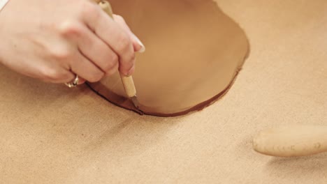 Hand-of-woman-with-golden-ring-cutting-clay,-close-up