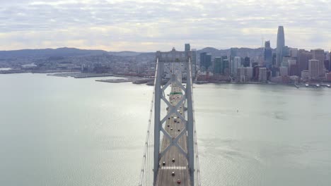 aerial: drivers crossing the bridge towards the city, drone view