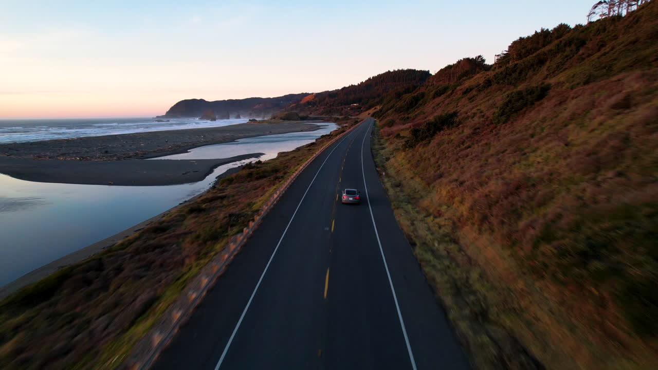 A car driving down the Oregon Coast Highway before sun set.