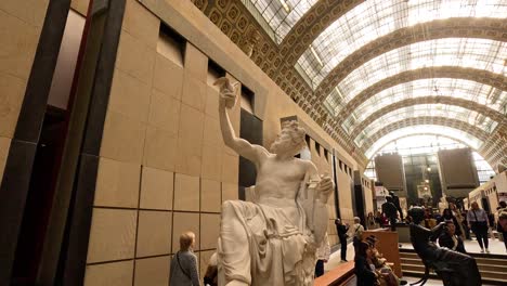 visitors admire statue in grand museum hall