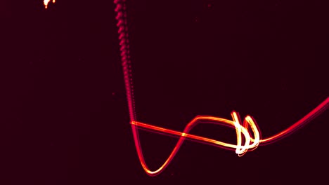 Two-glowing-red-lines-entertwining-moving-on-a-black-background