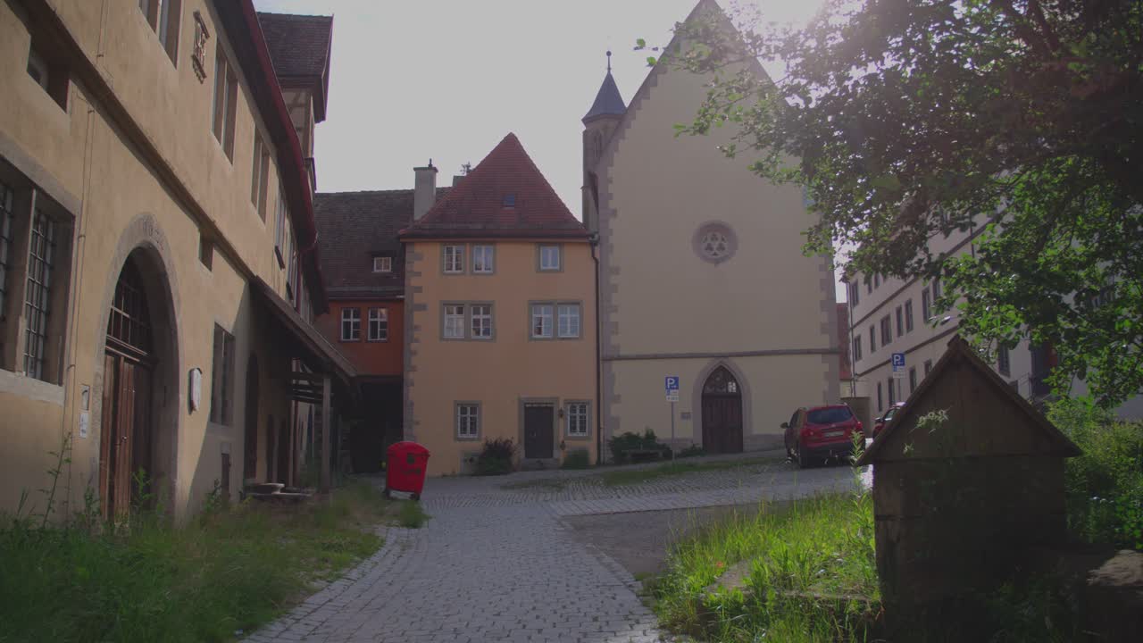 Narrow street with historic buildings in Rothenburg ob der Tauber on a sunny day