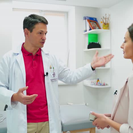 young doctor consulting female patient. male physician talking to beautiful woman. specialist explaining treatment to patient during check up visit in clinic.