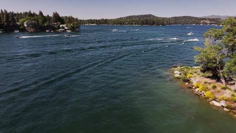 boats and yachts passing through the scene on lake arrowhead california summer sunny day aerial dolly