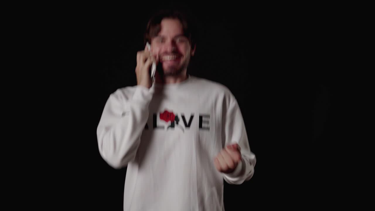 스마트폰에 흥분한 트렌디한 청년, 환호하는 몸짓, 넓고 검은 배경