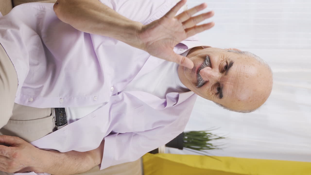 вертикальное видео старика, машущего камере.