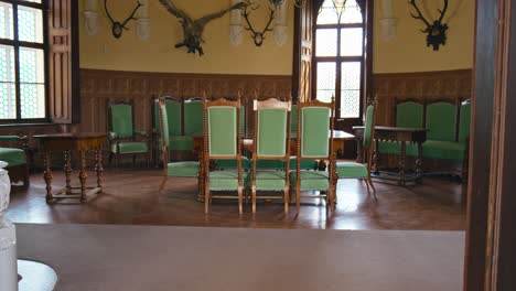 spacious hall with ornate chairs and a grand table at trakošćan castle's hunting hall