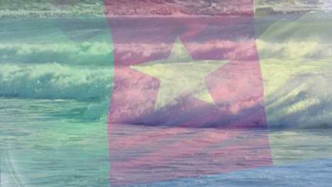 digital composition of cameroon flag waving against aerial view of waves in the sea