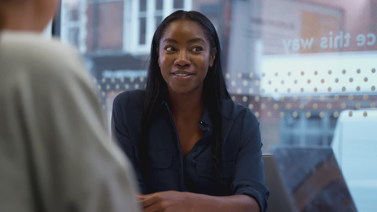 Young African American Businesswoman Sitting At Table In Office Meeting Room
