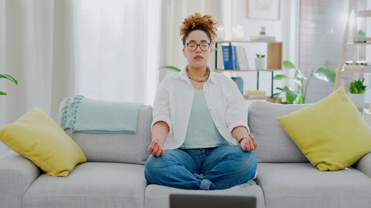 Nainen, jooga ja sohva kannettavan tietokoneen vieressä meditaatiossa