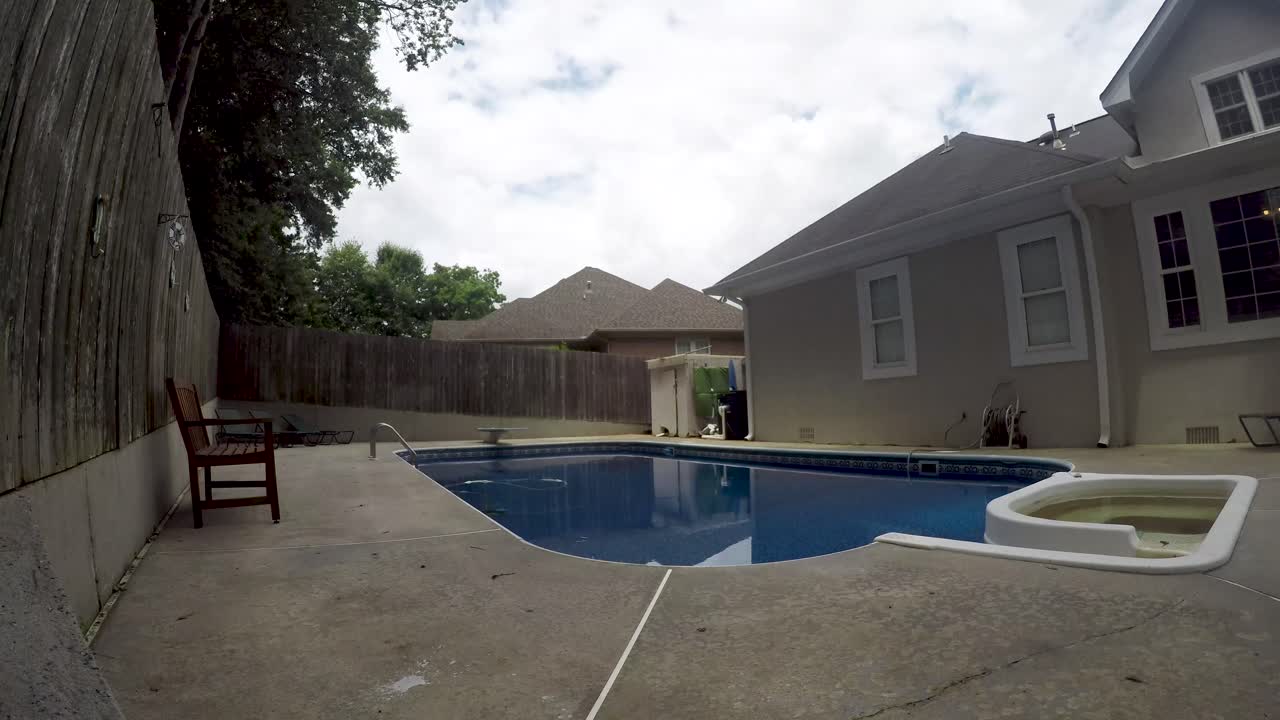 Cloud timelapse over a backyard inground swimming pool