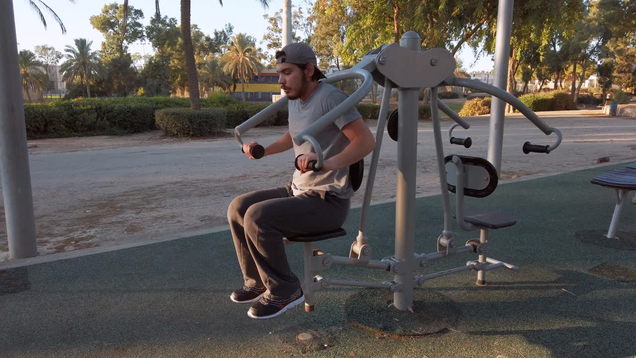 Ung mand løfter sin egen vægt i fitnessudstyr