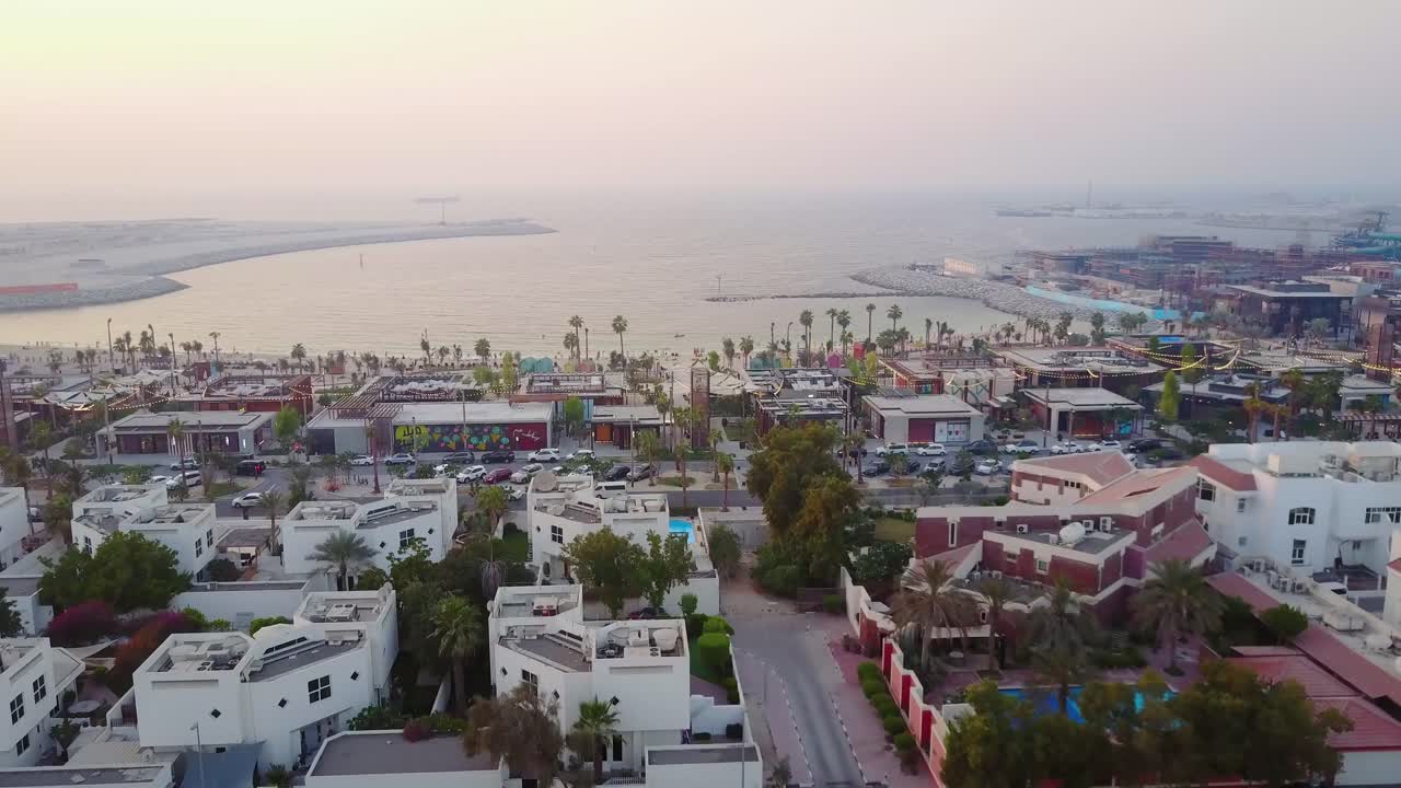 Vista aérea de un paisaje urbano costero con restaurantes y edificios residenciales