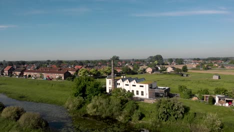 river ijssel scenery aerial view of ijsselstroom former industrial water management building with de hoven neighbourhood and glass houses in zutphen, the netherlands, in the background