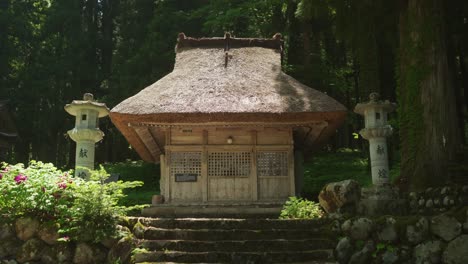 edificio de santuario sintoísta con techo de paja en shirakawago con el sol brillando en el techo